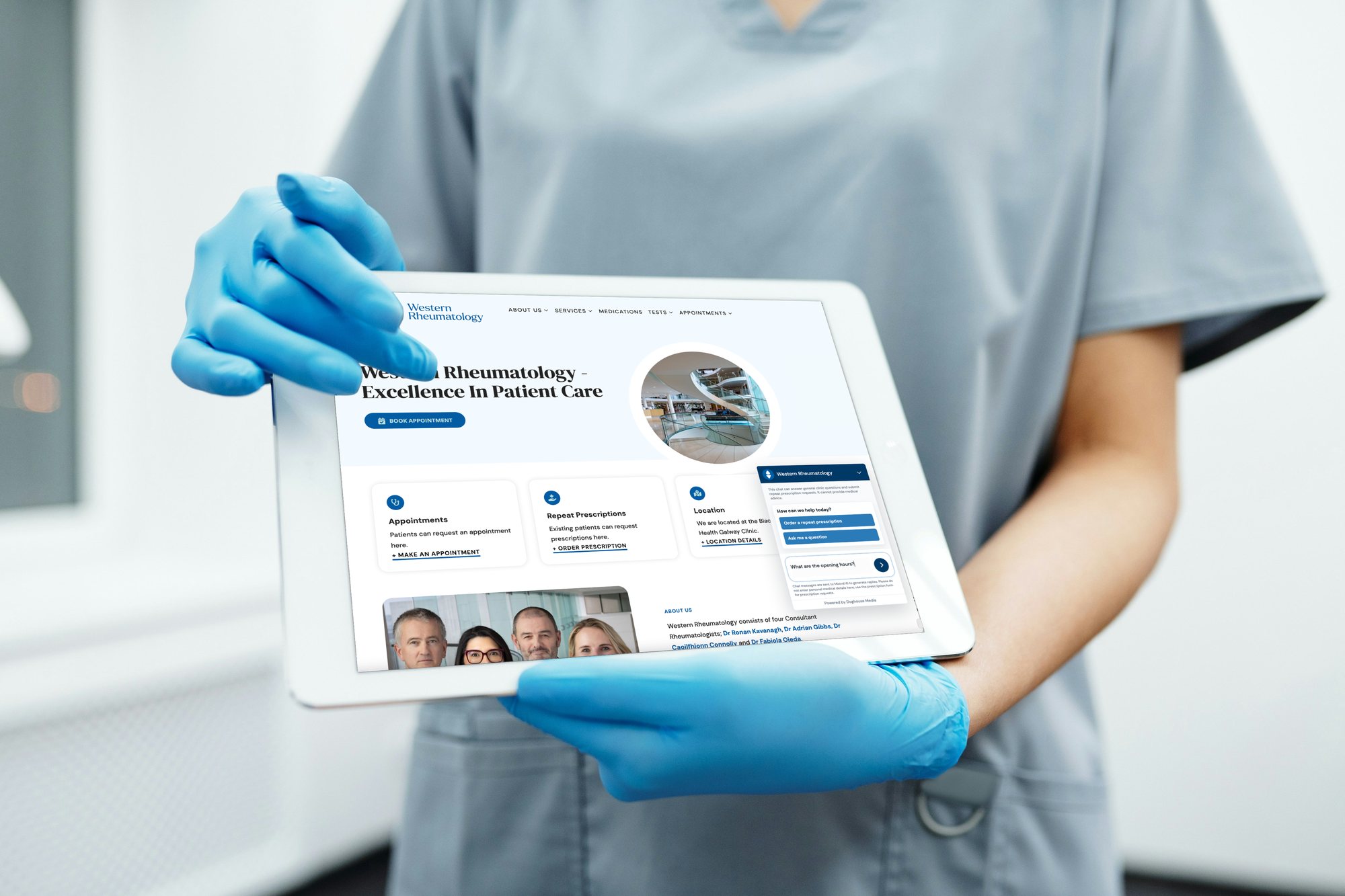 A member of clinic staff in blue gloves holding a tablet that shows the Western Rheumatology homepage, with the assistant open in the corner.